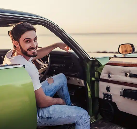 Latin man in a green classic car
