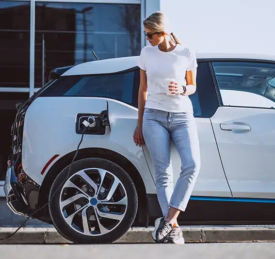 Woman charging electric car at the electric gas station