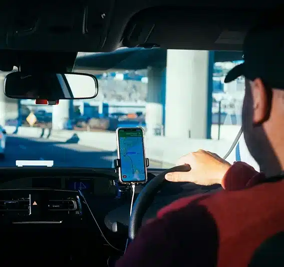 Man driving using mobile phone for navigation