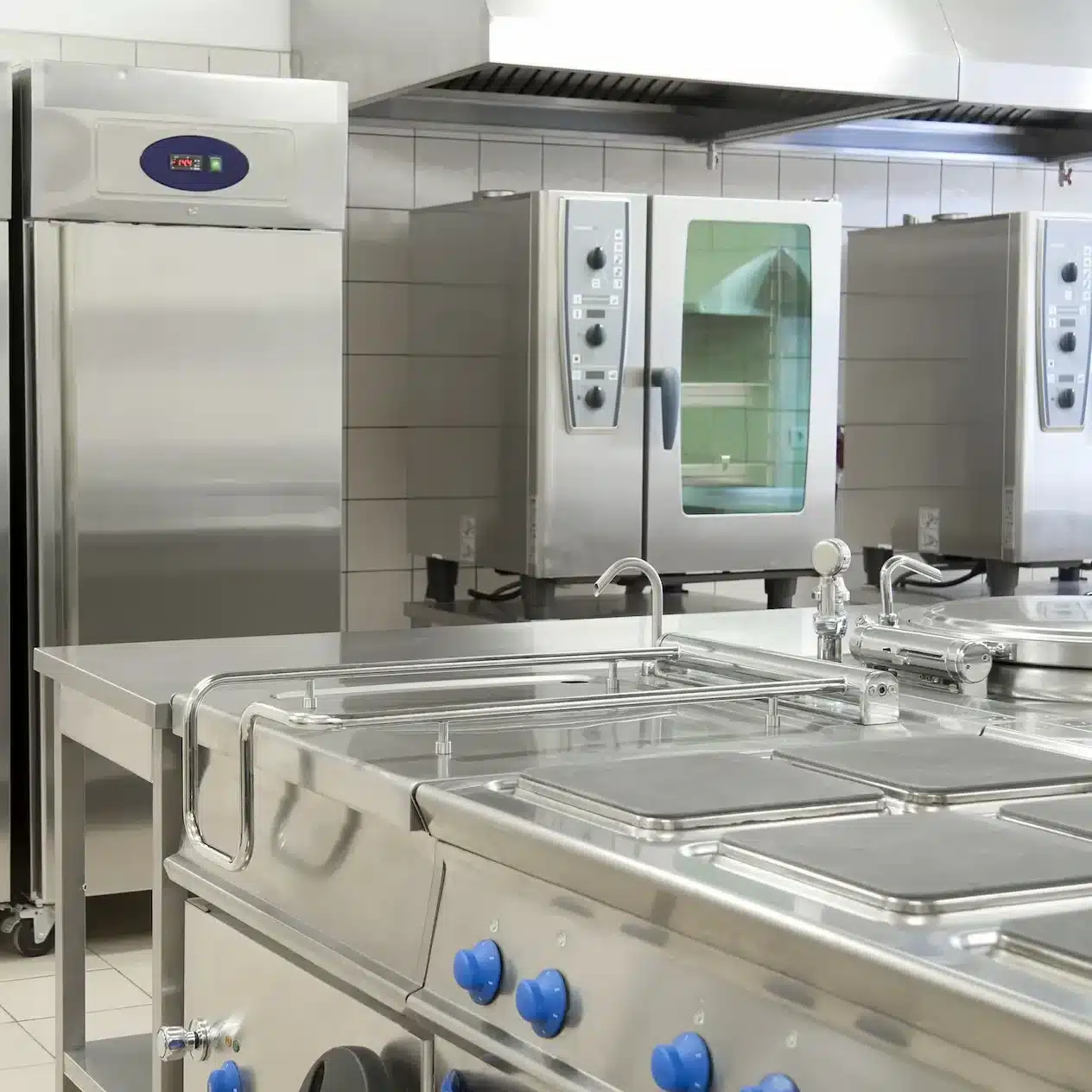 A modern kitchen with stainless steel appliances and work surfaces for commercial grade catering