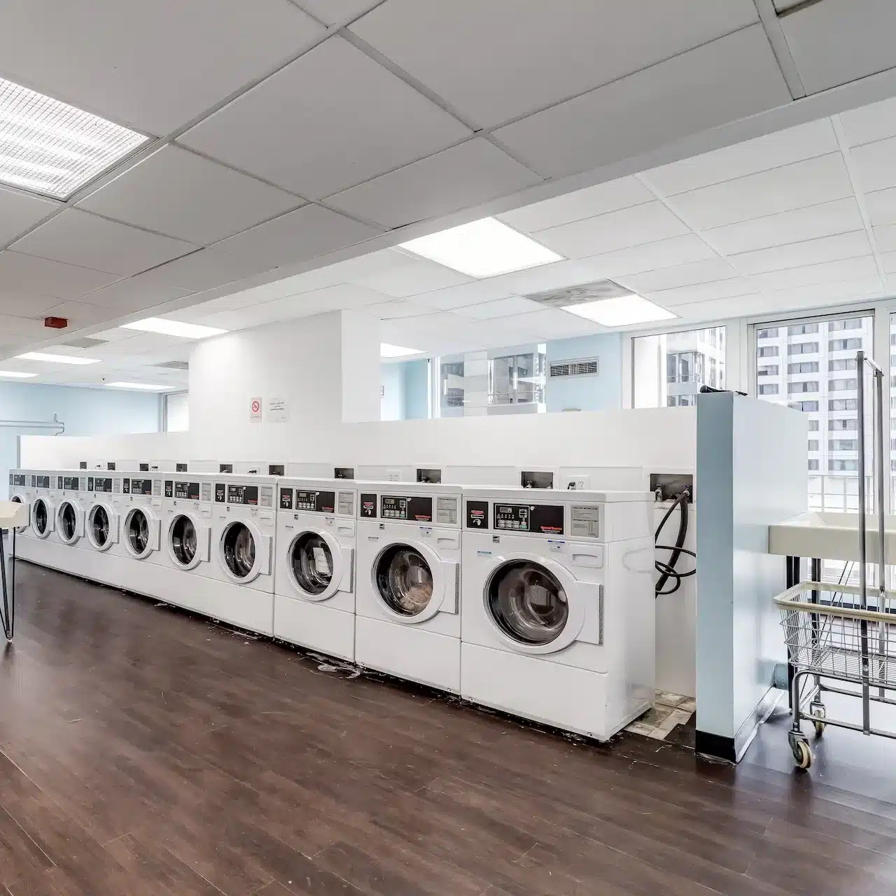 A modern laundromat with rows of washing machines and benches