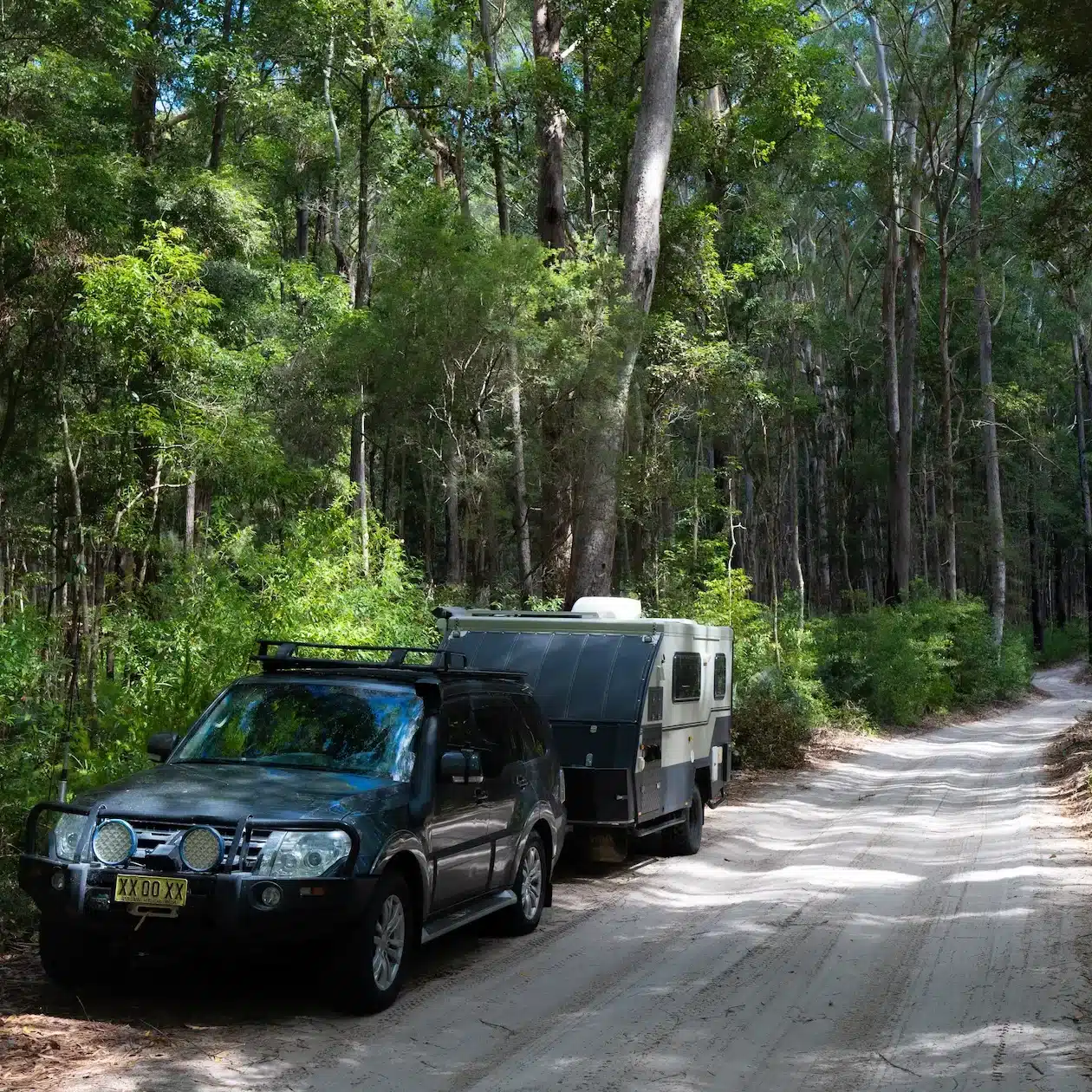 A 4WD and caravan pulled over on an inland track on K'Gari