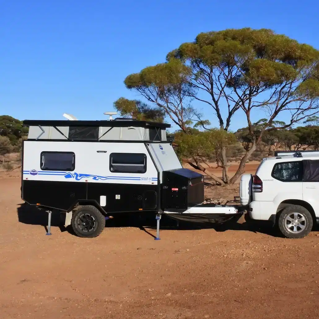A hybrid caravan hooked up to a 4WD touring the Australian outback