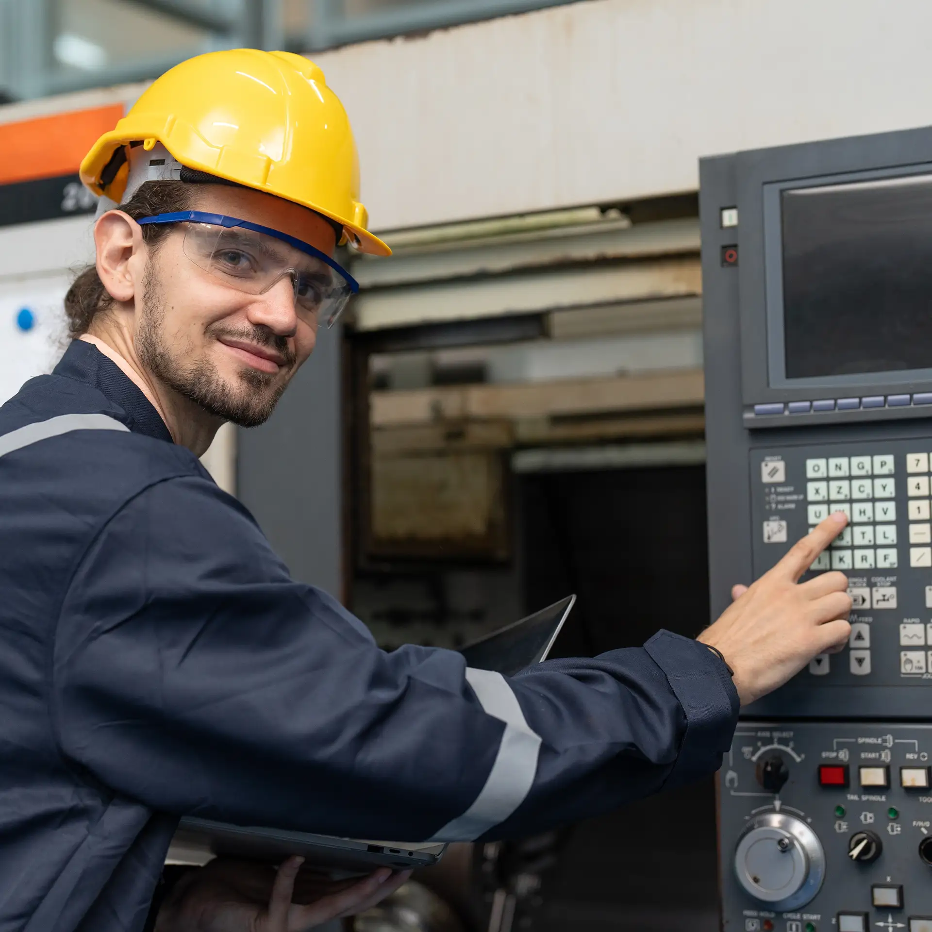 Male engineer operating cnc machine in control panel at factory