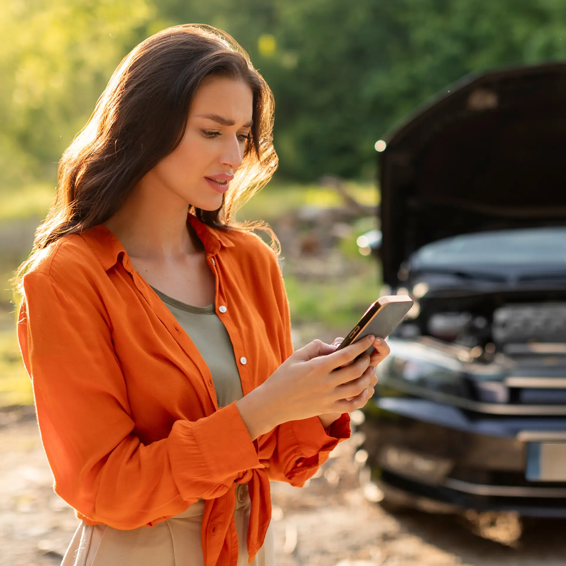Sad woman has broken down car on roadside