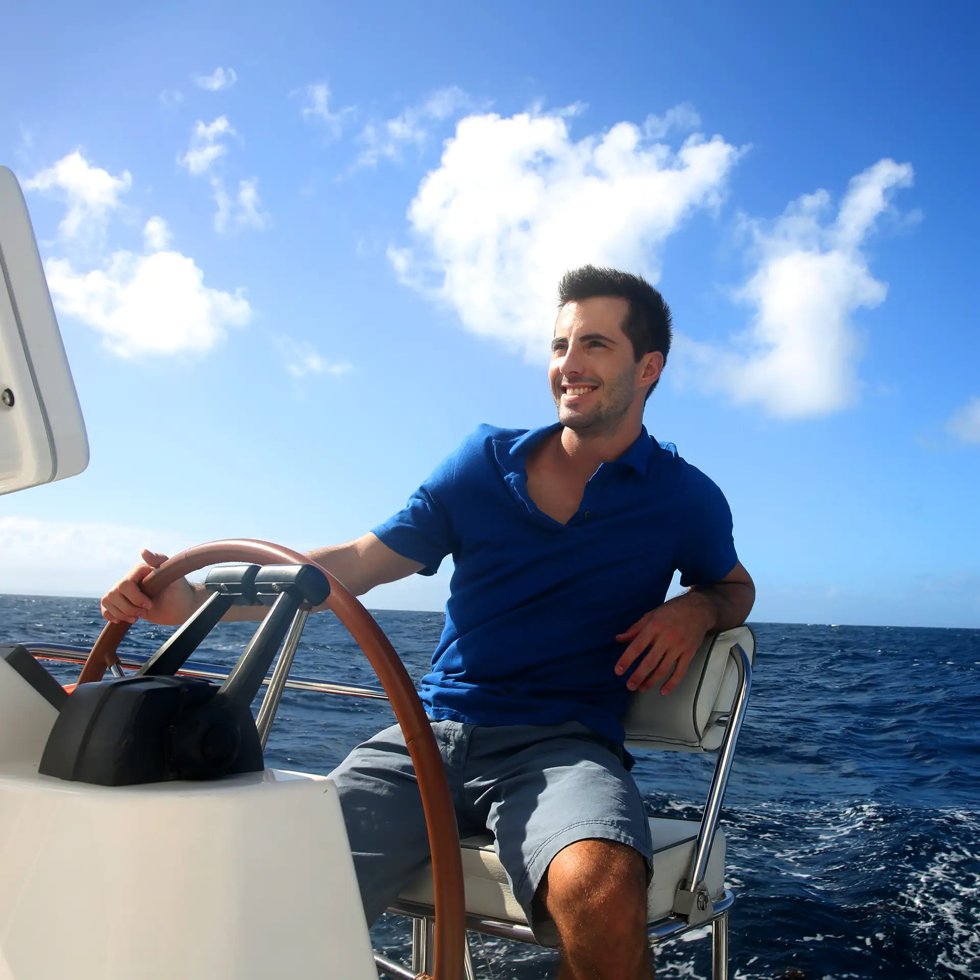 Smiling man sailing his new vessel after getting a better rate on his boat finance using Jade Finance's marine finance calculator.