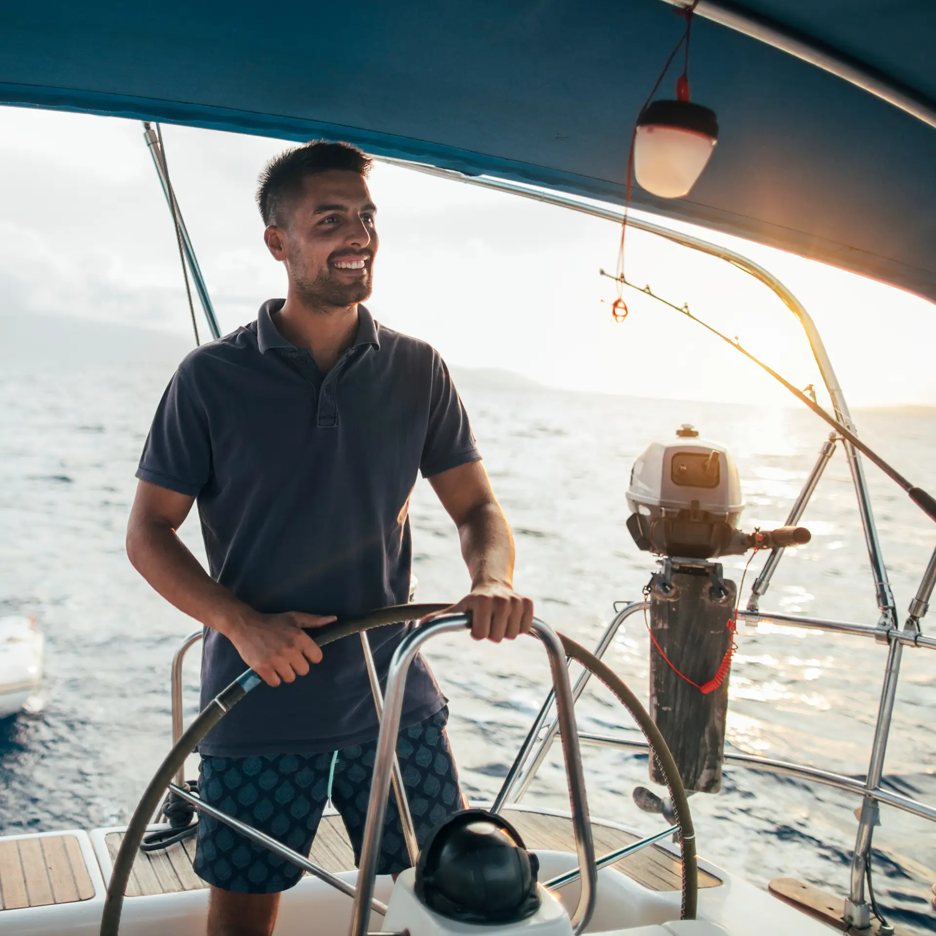 Smiling man as the helmsman on a sailboat