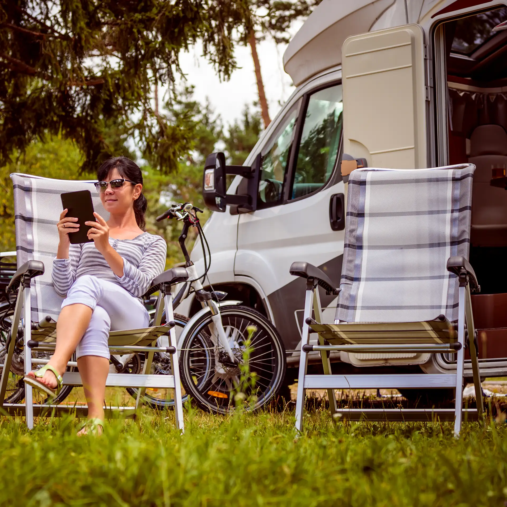 Woman looking at the tablet in the camping site