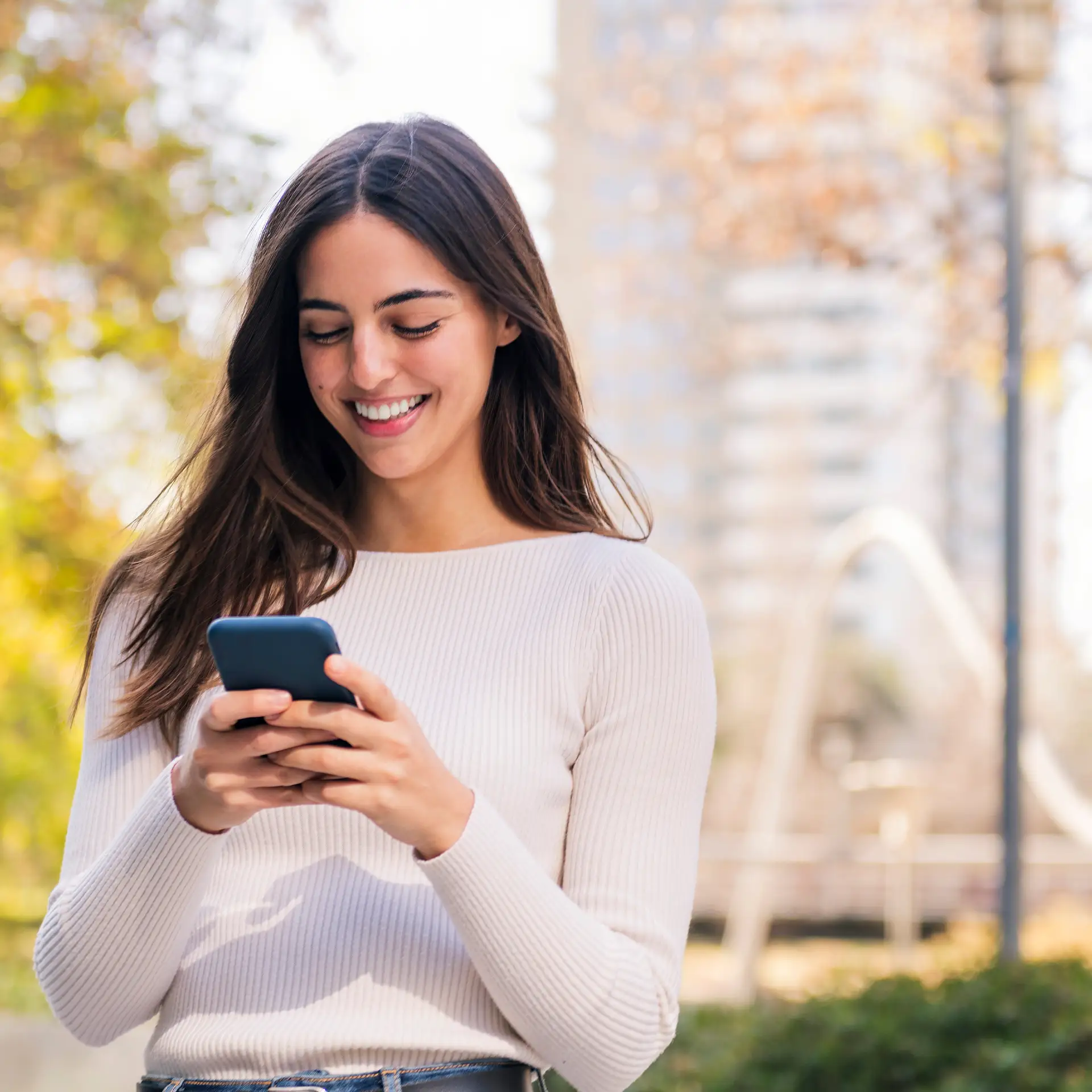 A smiling caucasian woman using her mobile phone