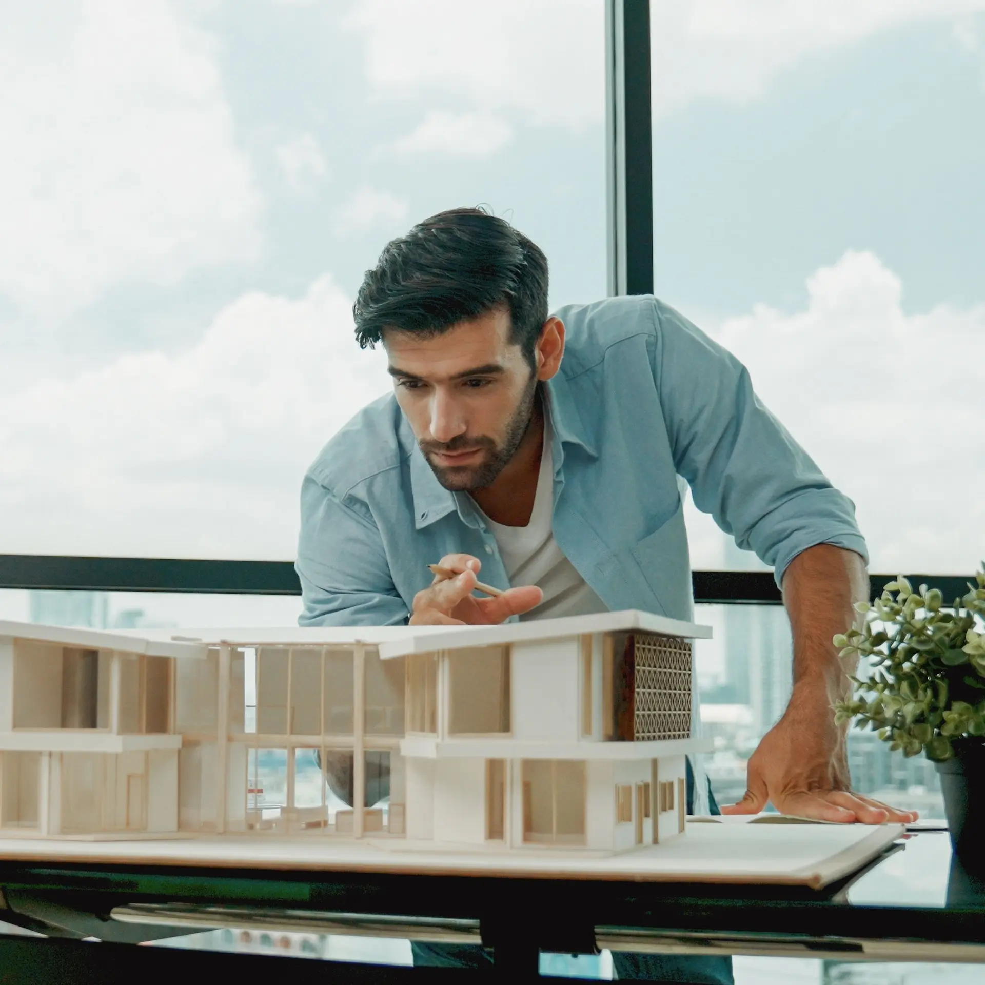 An architect is inspecting a model of a planned luxury residence.