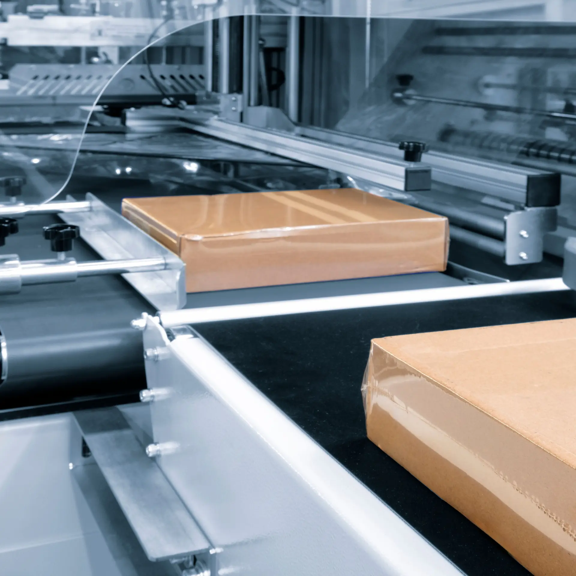 Packaging machines working in an industrial manufacturing facility.