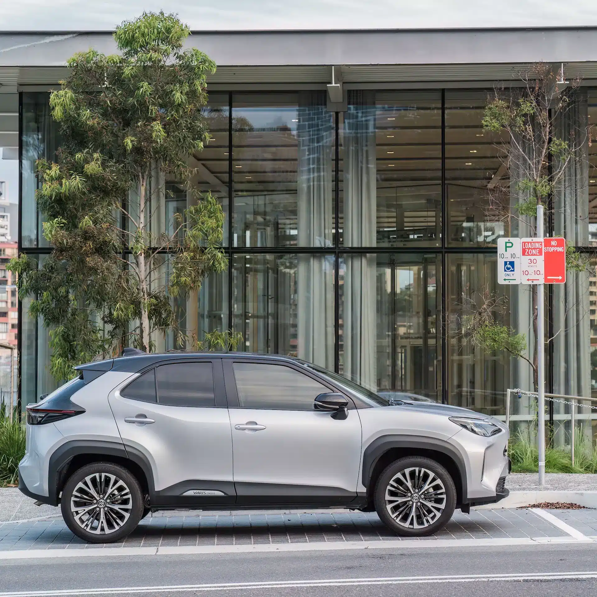 A new small Toyota SUV parked in front of a modern building.