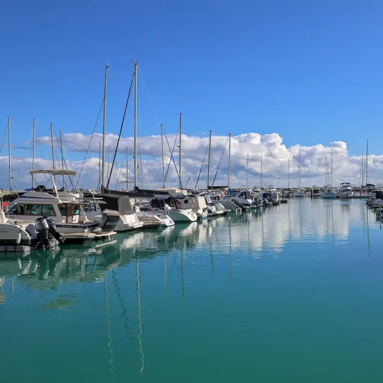 Boats docked on the water moored in Port Coogee Marina in Perth.