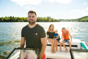Man driving boat on holiday with his son kids and his wife